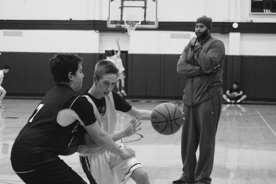 Assistant Coach Lamar Butler gives Jason Lansing tips as he guards Ryan Skok.