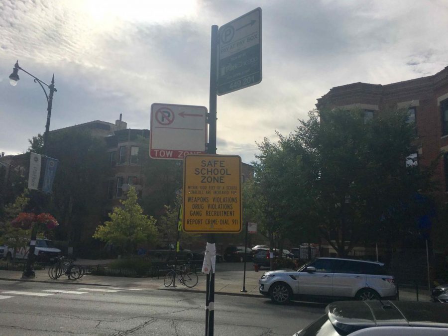 The “Safe School Zone” sign sits just below two other instructional signs on Clark Street.
