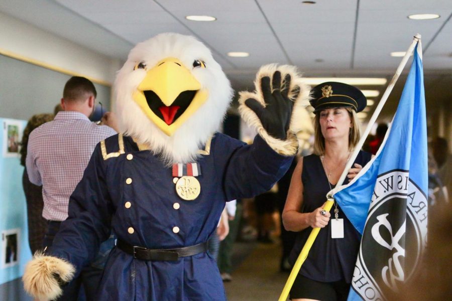 The new Eagle mascot waves in the Homecoming Rally next to upper school math teacher Vicki Lee.