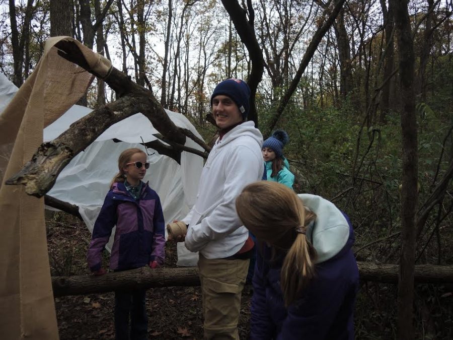Senior Jack Cordwell stands with string in hand next to a shelter in progress, as he helps his fifth grade group put it together.