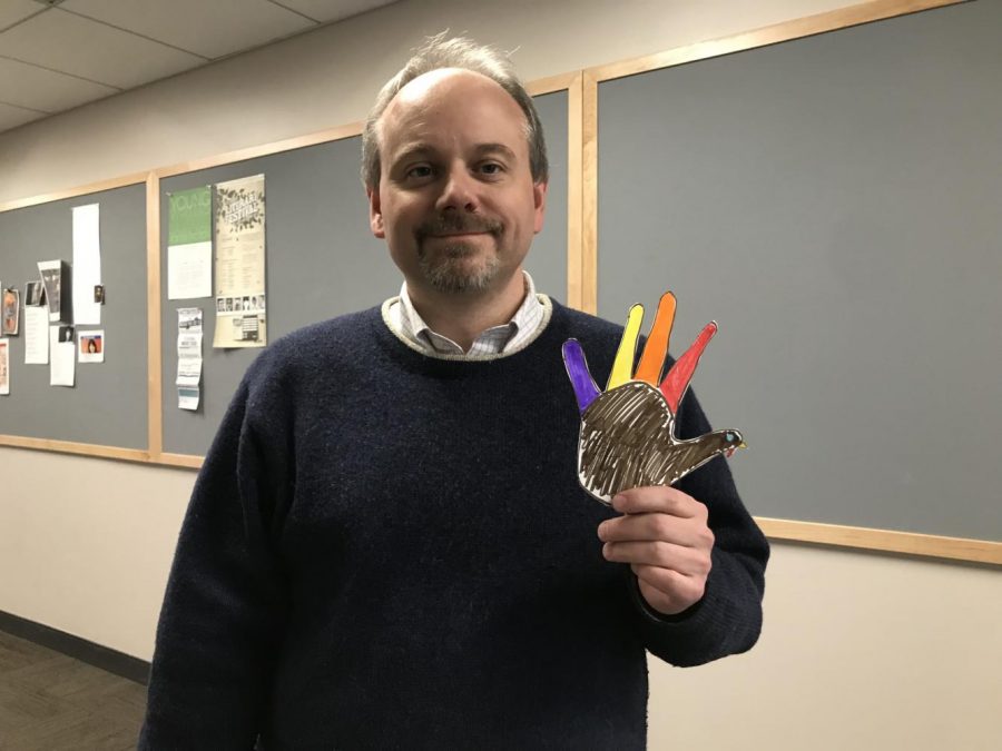 Upper School Math Teacher Christopher Riff poses with a hand turkey. 