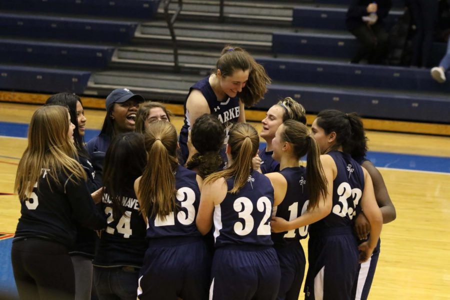 The+girls+basketball+team+lifts+Sophomore+Molly+Taylor+after+winning+their+Blue+Out+game.