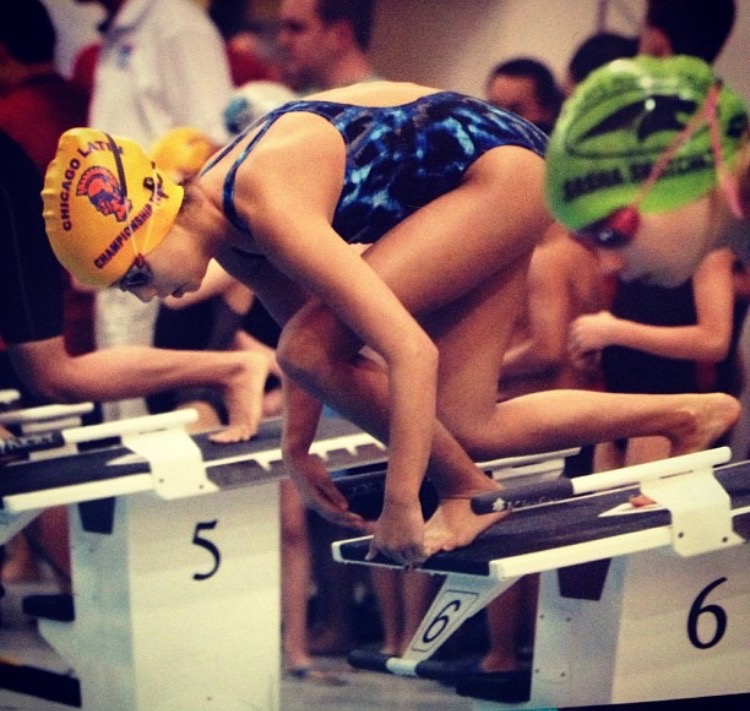 Sophomore Ava Stepan poses on the blocks, ready to dive into the pool at the start of her race.