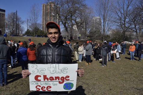 Sophomore Rohan Jain stands with his sign behind students gathered for the rally. “I’m marching to provide solidarity to the shooting that happened in Parkland, and trying to prevent gun violence in the future by taking action.”