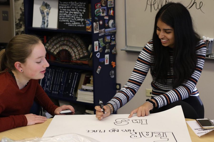 Lilly Satterfield (left) and Avani Kalra (right) make a political protest sign.