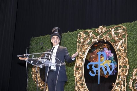 Principal Dan Frank 74, dressed as the Mad Hatter, speaks at the auction.