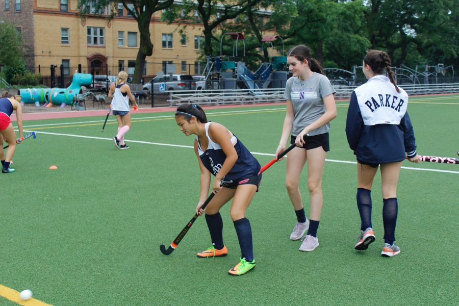 Emma Jung receives a pass while warming up during field hockey practice.
