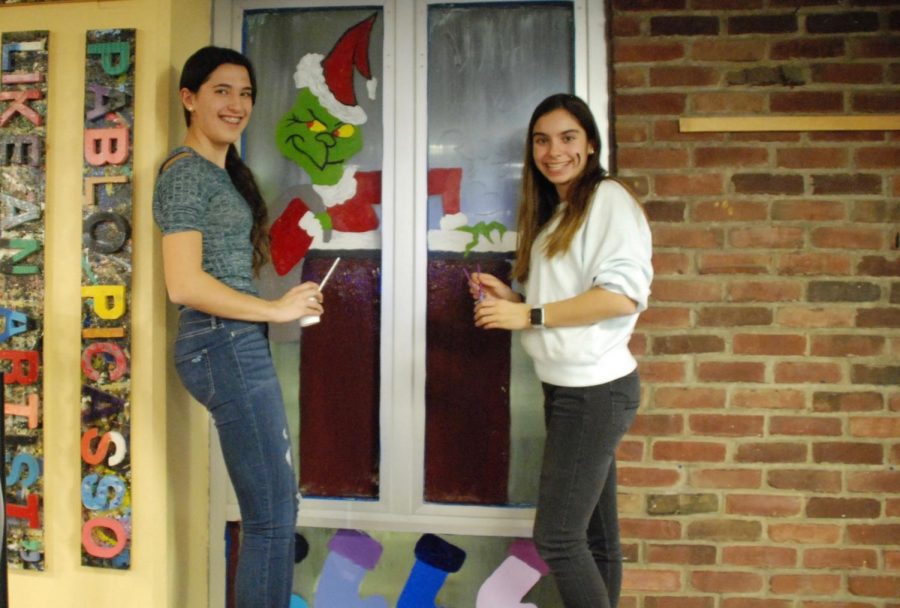 Freshman Alicia Berger and Sophia Rogers painting their windows in the front lobby.

