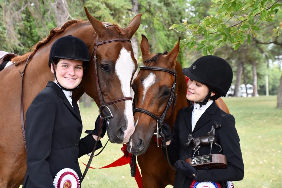 Buono (left) and Mansueto (right) admire their horses, Buggati LOE and Above Aire V, after placing seventh and first, respectively, in a hunt seat equitation class at Canadian Nationals in Manitoba.