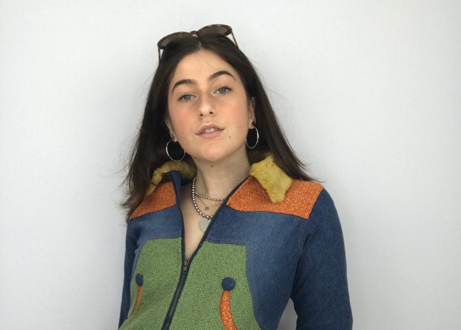 Junior Raven Rothkopf poses with the clothing she  is trying to sell on Depop.