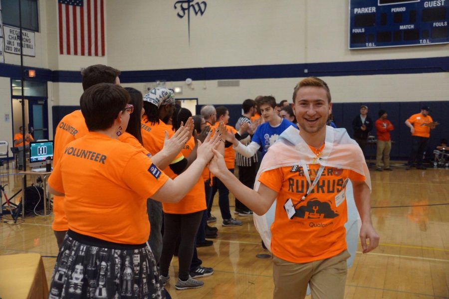Senior Nathan Satterfield leads Parker’s “Robotheosis” down a high-five line after winning the FIRST Robotics “Control Award,” one of the team’s several accolades.