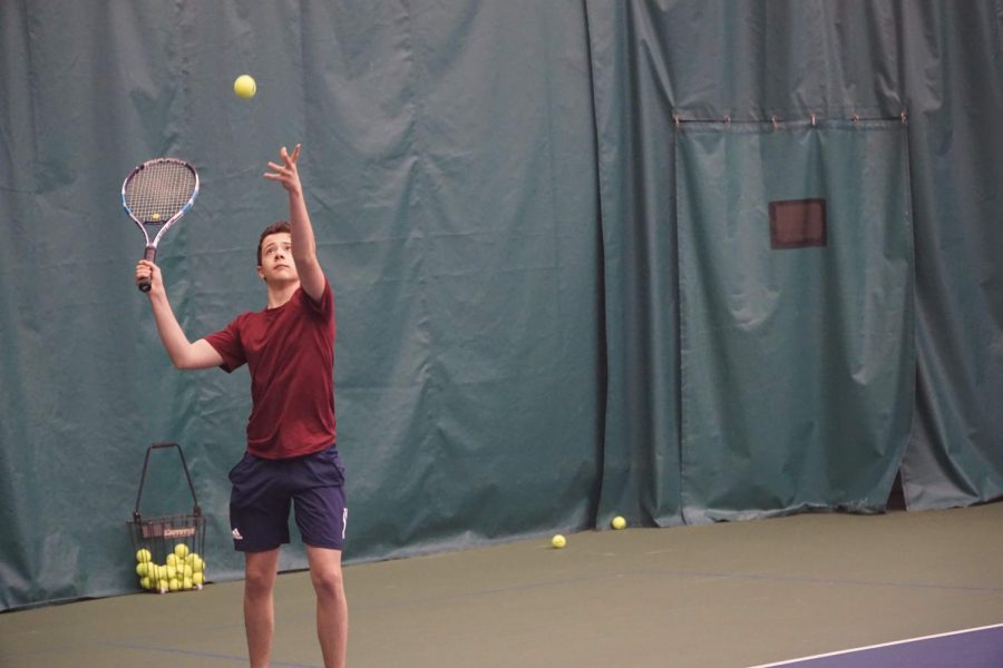 Junior Matthew Garchik serving at tennis practice.
