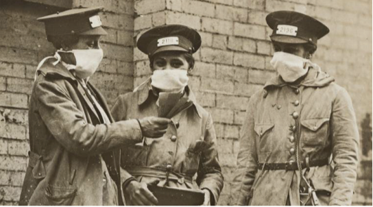 A group of New York train conductors converse while wearing gauze masks during the 1918 flu pandemic. Photo courtesy of the National Archives.