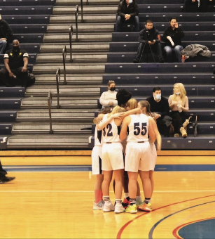 The Girls Basketball Team pauses for a huddle. 