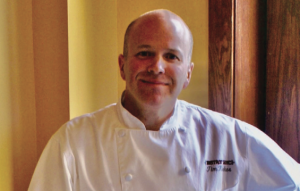 Executive Chef Tim Kirker poses in his chef garb.