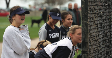Four members of Parkers softball team cheer on their teammates at their first ever Spring Showcase game. 