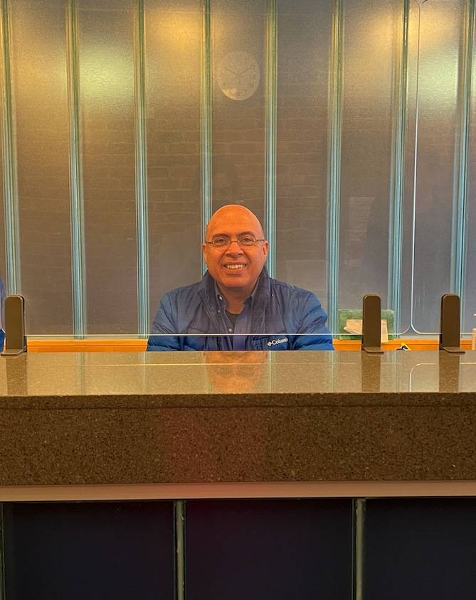 Parker security office Sahid Mohamed smiles behind security desk. Photo by Naomi Gross.