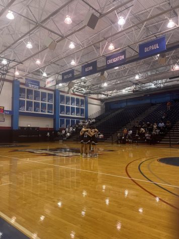 The girls huddle before their game against Latin with a near empty Parker crowd behind them