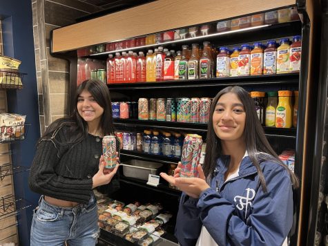 Juniors Kyra Mathew (left) and Riya Jain (right) pose with the fully stocked shelf of Arizona iced teas in the Cafeteria.