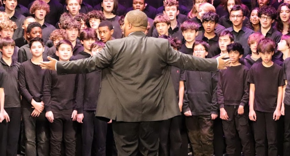 Choir teacher Christian Jackson conducts a choir of middle schoolers at the Winter Choral Concert. 