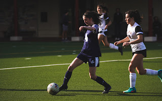 Anna Swanson dribbles in Varsity soccer game against Lake Forest Academy on the Parker field.
