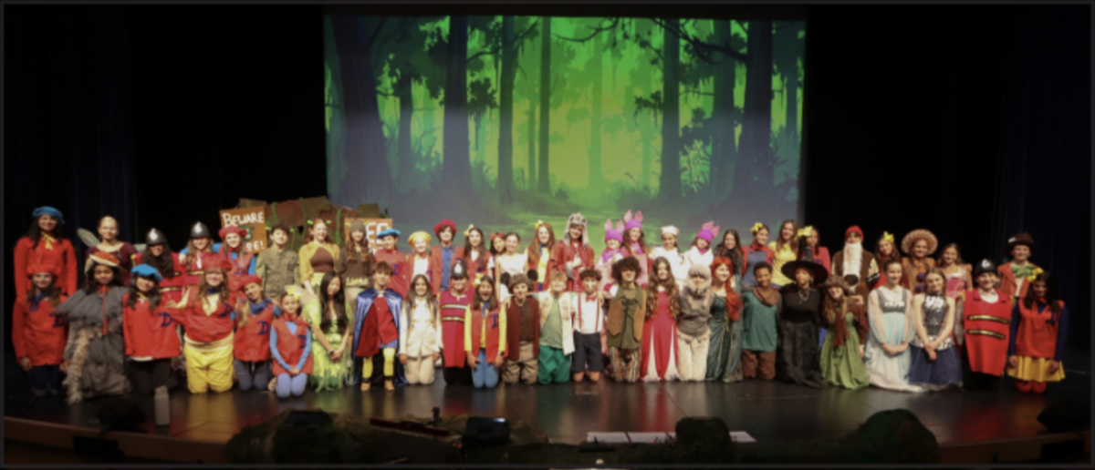 The cast of Shrek the Musical smiling on stage after their final show